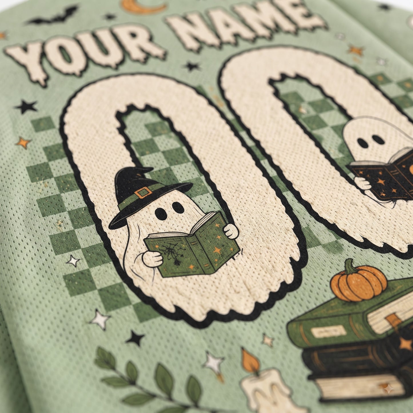 Close-up of a personalized Halloween-themed sports jersey fabric with a mint green mesh texture. The design features a large number '00' with cute cartoon ghosts inside, one wearing a witch hat and reading a book, and another ghost reading a book on the right.