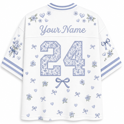 White mesh custom sports jersey shown from the back, featuring a floral patterned number 24, 'Your Name' text, and matching blue and lavender floral prints on the sleeves and shoulders.