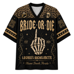 A women's short-sleeve V-neck t-shirt featuring a green frog in a yellow dress holding a diamond ring, with the text 'Engaged, m'lord' on the front. The shirt has sage green patterned sleeves and a cream-colored central panel.