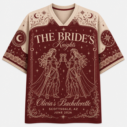 A short-sleeve V-neck t-shirt with a bachelorette graphic design. The shirt features a deep burgundy red body with cream-colored text reading 'THE BRIDE's Knights' and 'Olivia's Bachelorette', along with line-art illustrations of two knights holding cups under a crescent moon and stars.