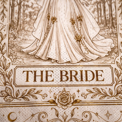 A close-up of a printed textile or fabric design featuring an illustration of a bride's flowing gown in a forest scene, with the words 'THE BRIDE' in a decorative panel and floral border details.