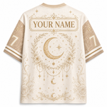 Back view of a short-sleeve athletic jersey in cream with gold celestial graphics, including a large crescent moon, stars, floral wreath, and a customizable name patch reading 'YOUR NAME'.