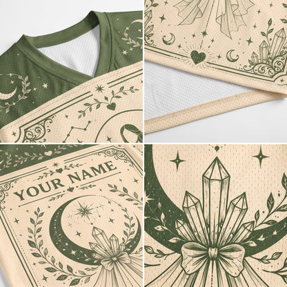 A four-panel close-up collage of a cream-colored athletic jersey with dark green celestial and crystal-themed graphics, including a V-neck collar, sleeve pattern, 'YOUR NAME' placeholder print area, and a large crystal-and-moon motif.