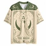 A short-sleeve V-neck t-shirt with a celestial 'The Bride' tarot card design. The shirt features a dark green collar and shoulders, cream-colored sleeves and main body, and a central graphic of a bride in a gown standing before a crescent moon and stars, with the text 'THE BRIDE' at the bottom.