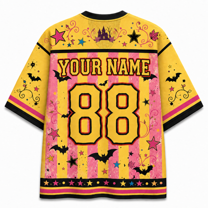 A yellow and pink striped short-sleeve jersey shown from the back, featuring customizable text 'YOUR NAME' and the number '88' in large yellow letters. The design includes black bats, pink and yellow stars, black swirls, a purple castle, and a black top and bottom hem.