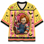 A yellow short-sleeve t-shirt with a horror-themed graphic print of Chucky holding a bloody knife, set against a pink and yellow patterned background with black trim.