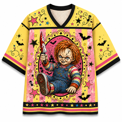 A yellow short-sleeve t-shirt with a horror-themed graphic print of Chucky holding a bloody knife, set against a pink and yellow patterned background with black trim.