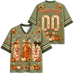 Front and back views of a customizable sage green V-neck t-shirt with a fall harvest theme. The shirt features a graphic print of three 'Dixie Coke' style milk/drink bottles, pumpkins, sunflowers, and plaid bows.