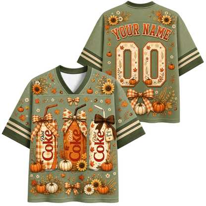 Front and back views of a customizable sage green V-neck t-shirt with a fall harvest theme. The shirt features a graphic print of three 'Dixie Coke' style milk/drink bottles, pumpkins, sunflowers, and plaid bows.