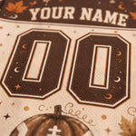 Close-up of a customizable sports jersey fabric with 'YOUR NAME' at the top, large '00' numbers, and a pumpkin graphic at the bottom.