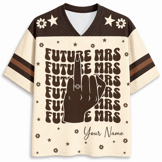 A short-sleeve V-neck t-shirt with a cream and dark brown color-blocked design. The front features a large graphic of a hand making a peace sign with the ring finger raised, surrounded by the text 'FUTURE MRS' repeated in a retro font, with 'Your Name' written at the bottom.