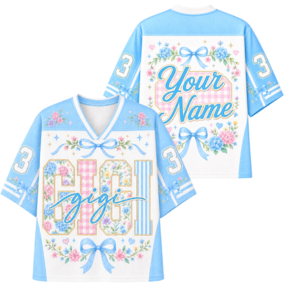 A short-sleeve t-shirt with a Halloween-themed graphic print on the back. The design features a cream-colored top panel with butterflies and floral borders, a dark brown lower body, and a central graphic of a cute ghost wearing an orange bow and holding a jack-o'-lantern basket, surrounded by flowers and the text 'Your Name'.