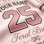 Close-up of a white mesh sports jersey with pink and black custom text, featuring the number 25 and the words 'YOUR NAME' and 'Feral Bride' with small pink hearts.
