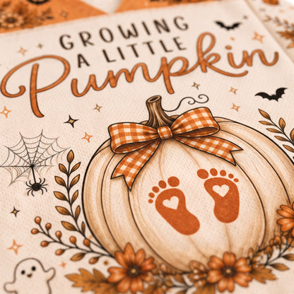 Close-up of a printed pumpkin-themed design with the phrase “Growing a Little Pumpkin” in brown lettering, a large cream pumpkin illustration with an orange gingham bow, orange baby footprints, autumn leaves, flowers, spiders, bats, and a ghost.