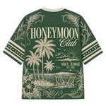 A green short-sleeve t-shirt with a cream-colored graphic print on the back, featuring palm trees, beach chairs, and the text 'HONEYMOON Club' and 'MAUI, HAWAII EST. 2026'.