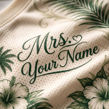 Close-up of a cream-colored mesh fabric with green tropical floral print and the text 'Mrs. Your Name' in dark green script.