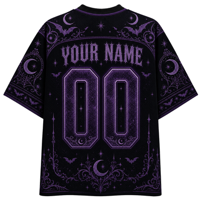 A black short-sleeve t-shirt with a purple gothic-themed graphic print on the back, featuring customizable text 'YOUR NAME' and '00' in a stylized font with moon, bat, and spiderweb motifs.