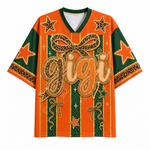 An orange and green graphic t-shirt with a leopard print bow, stars, and the word 'gigi' in large gold script on the front, displayed on a clean white background.