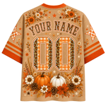 A personalized short-sleeve t-shirt with a fall theme, featuring orange and beige gingham patterns, pumpkins, autumn leaves, and customizable text 'YOUR NAME' and '00' on the back.