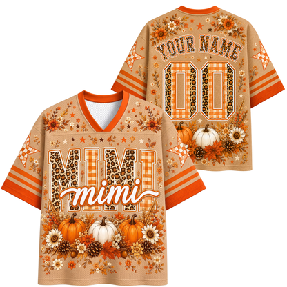 A personalized fall-themed short-sleeve V-neck jersey shirt shown from both front and back. The base color is a warm tan/beige, decorated with orange stripes, orange and brown leopard print lettering, white pumpkins, pinecones, and autumn flowers.