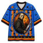 A short-sleeve V-neck T-shirt with a Halloween-themed horror graphic print. The design features a central oval portrait of Jason Voorhees holding a bloody knife, set against orange and blue striped background elements with bats, stars, and a haunted house motif.