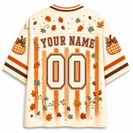 A cream-colored mesh football-style jersey shown from the back, featuring personalized print graphics including 'YOUR NAME', the number '00', orange and brown stripes, fall leaves, acorns, pumpkins, and decorative swirls.
