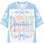 A custom football-style jersey shown from the front and back, featuring a brown and beige color scheme with a cartoon ghost holding a pumpkin and cup, surrounded by flowers and butterflies. The back has a placeholder text 'Your Name' and the front has 'Growing a little boo'.
