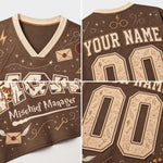 A brown V-neck jersey shown in a four-panel collage, featuring cream-colored graphics and text including 'YOUR NAME', 'Mischief Manager', and large customizable numbers. The design includes witch-hat motifs, stars, lightning bolts, and envelope illustrations.