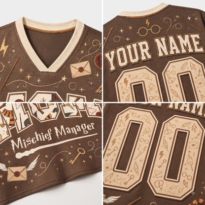A brown V-neck jersey shown in a four-panel collage, featuring cream-colored graphics and text including 'YOUR NAME', 'Mischief Manager', and large customizable numbers. The design includes witch-hat motifs, stars, lightning bolts, and envelope illustrations.
