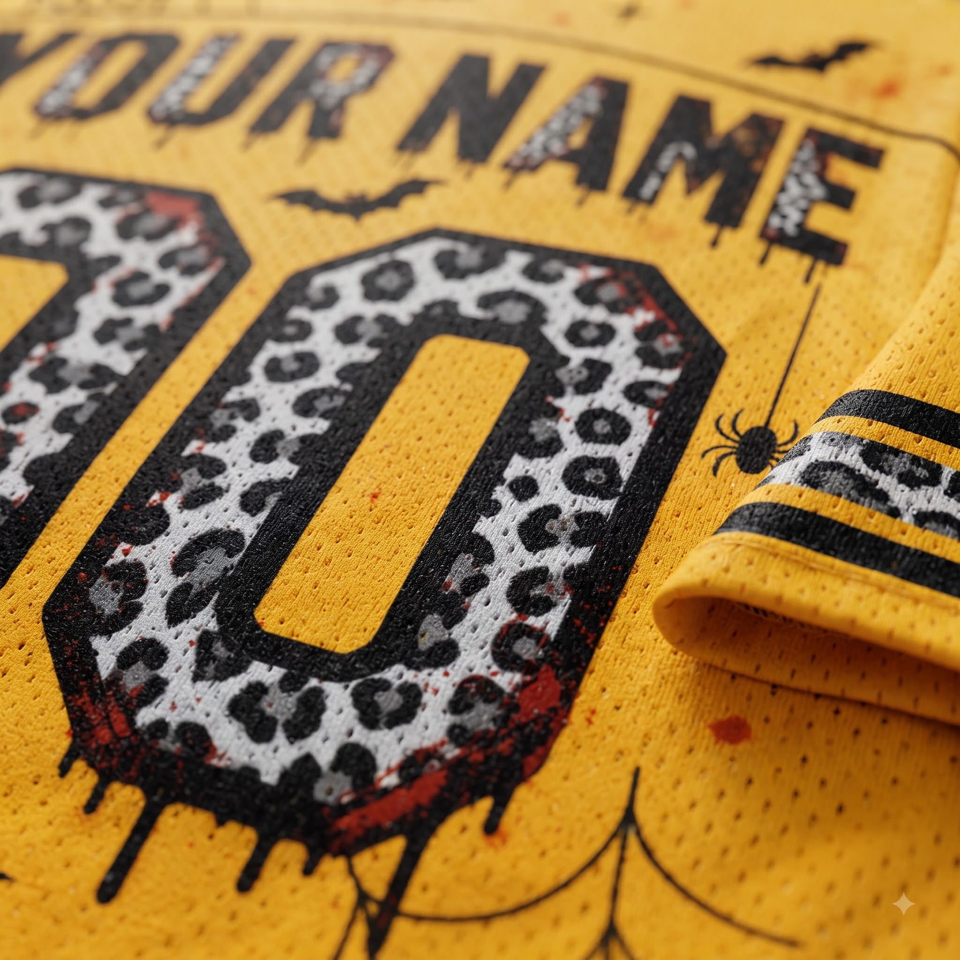 Close-up of a yellow mesh jersey with a custom graphic print featuring a leopard-print number, black dripping text, and Halloween-themed details like bats and a spider.