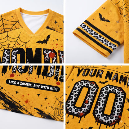 A yellow V-neck t-shirt with a Halloween zombie theme, shown in a four-panel collage highlighting details: the front graphic with 'ZOMBIE' in leopard print, a sleeve with black stripes and leopard print, the front text 'LIKE A ZOMBIE, BUT WITH KIDS', and a customizable back graphic with 'YOUR NAME' and leopard print numbers '00'.