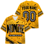 A yellow short-sleeve V-neck jersey shown from the front and back, decorated with Halloween graphics including spiderwebs, black bats, splatters, and leopard-print lettering that reads 'NOMIE' and 'YOUR NAME' with '00' on the back.