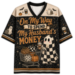A short-sleeve V-neck t-shirt with a Halloween-themed 'MAMA' graphic. The shirt features a black body with purple and orange shoulder panels, decorated with bats, stars, and spiderwebs.