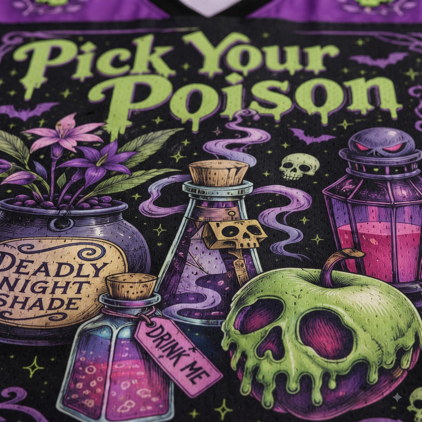 Close-up of a graphic t-shirt featuring a gothic Halloween design with the text 'Pick Your Poison' in dripping lime green font. The graphic includes a skull-faced green apple, a potion bottle labeled 'DRINK ME', a cauldron with purple flowers and the text 'DEADLY NIGHT SHADE', and other spooky elements on a black background with purple accents.