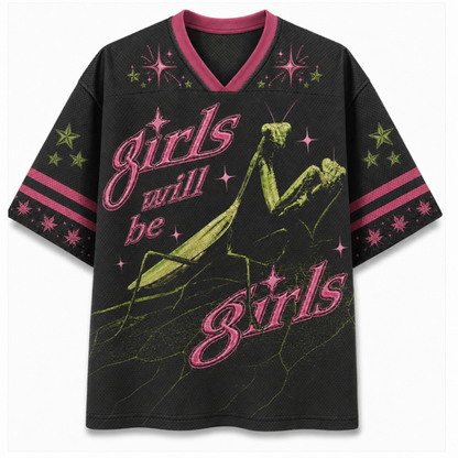A black short-sleeve V-neck jersey-style graphic top with pink trim and a large graphic print featuring a green praying mantis, pink script text reading 'girls will be girls,' and pink and green starburst accents on the chest and sleeves.