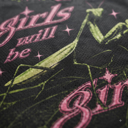 Close-up of a black mesh fabric featuring a green praying mantis graphic and pink gothic-style text reading 'girls will be'.