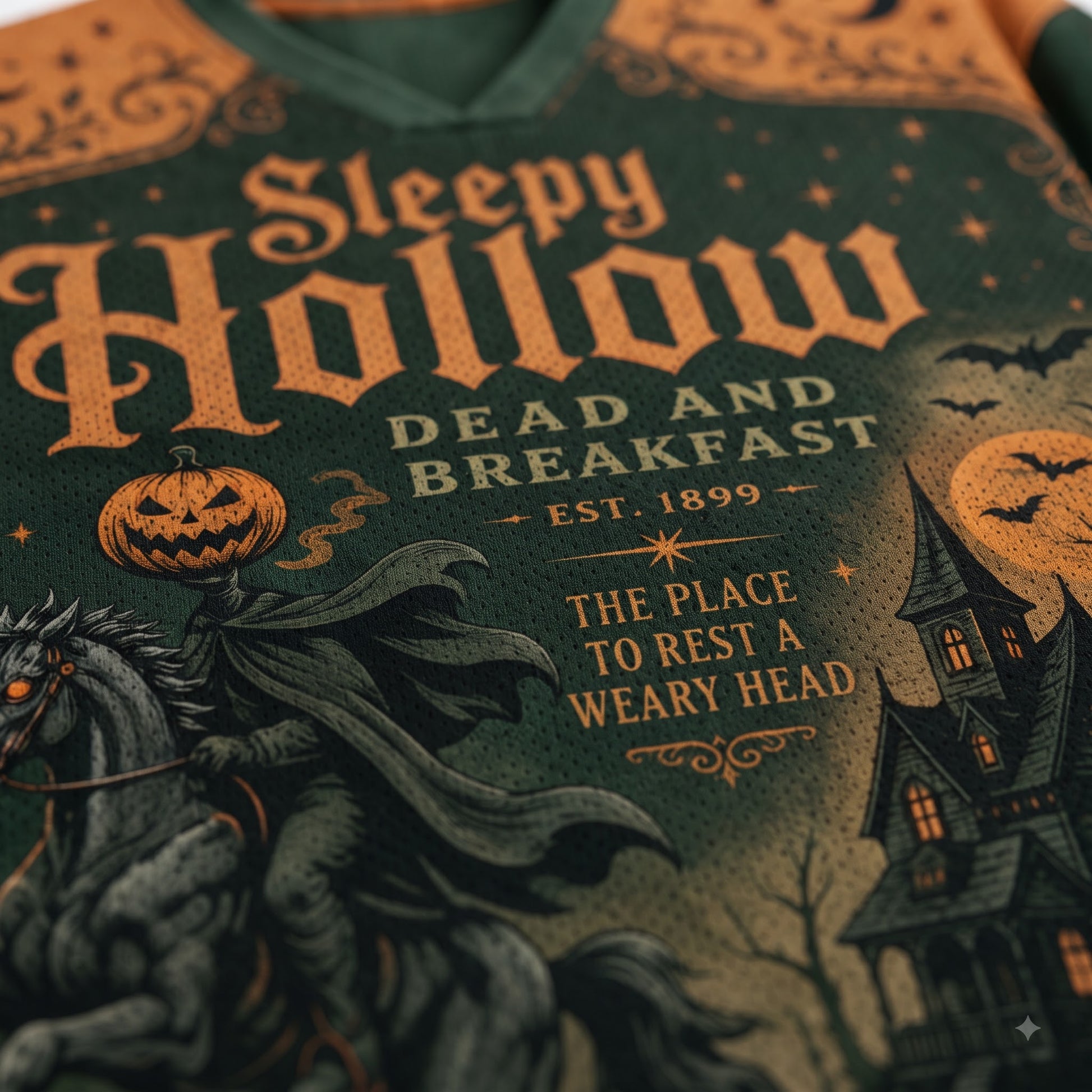 Close-up of a Halloween-themed graphic sweatshirt featuring the text 'Sleepy Hollow Dead and Breakfast' with a spooky illustration of a horse, pumpkin, moon, and haunted house.