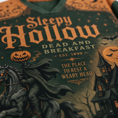 Close-up of a Halloween-themed graphic sweatshirt featuring the text 'Sleepy Hollow Dead and Breakfast' with a spooky illustration of a horse, pumpkin, moon, and haunted house.