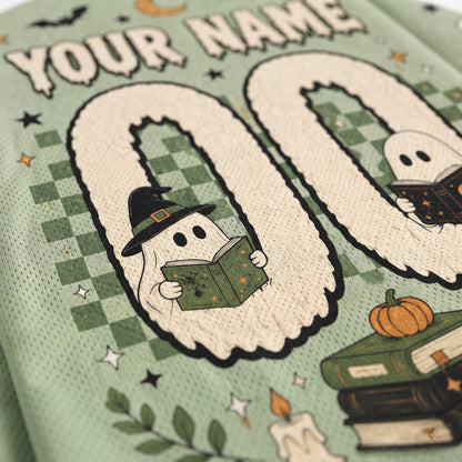 Close-up of a personalized Halloween-themed sports jersey fabric with a mint green mesh texture. The design features a large number '00' with cute cartoon ghosts inside, one wearing a witch hat and reading a book, and another ghost reading a book on the right.