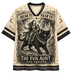 A cream-colored short-sleeve V-neck t-shirt with black trim, featuring a detailed black-and-cream graphic print of a woman riding a black cat with the text 'HEAR YE! HEAR YE! THE FUN AUNT HAS ARRIVED'.