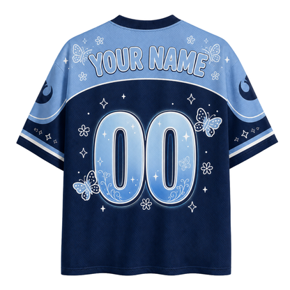 Customizable short-sleeve jersey-style shirt shown from the back, with a dark navy body, light blue upper back and sleeves, white decorative floral and butterfly motifs, and large placeholder numbers '00' with 'YOUR NAME' above them.