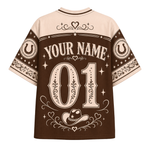 A brown and beige short-sleeve t-shirt with a western-themed back graphic featuring 'YOUR NAME 01' in large decorative numbers, horseshoes, stars, and a cowboy hat illustration.