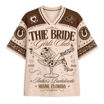 A short-sleeve V-neck t-shirt with a detailed bachelorette graphic. The shirt features a cream-colored body with red shoulders and sleeves, decorated with celestial and ornamental patterns.