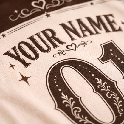 Close-up of a custom sports jersey featuring a cream-colored mesh fabric with dark brown printed text reading 'YOUR NAME' and a large decorative number '01'.