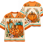 A short-sleeve V-neck t-shirt with a detailed autumn pumpkin illustration on the front, shown alongside a matching back view. The shirt features orange, teal, and cream colors with floral accents.