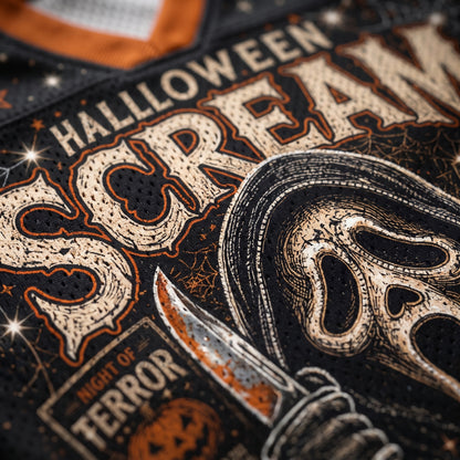 Close-up of a black perforated graphic print featuring distressed cream lettering that reads 'HALLOWEEN SCARE' with an illustrated ghost-face figure holding a knife and a small 'NIGHT OF TERROR' label.