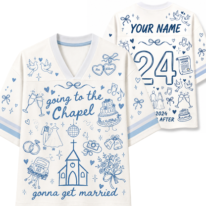 White V-neck t-shirt with blue line art and text, shown in front and back views. The front reads 'going to the Chapel' with wedding-themed doodles like a church, cake, rings, and champagne glasses.