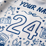 Close-up of a white textured sports jersey with blue line-art illustrations and the number 24, including small wedding-themed doodles and partial custom text reading 'YOUR NA.