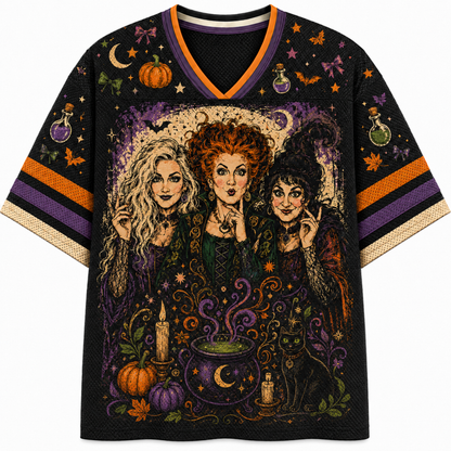 A black V-neck t-shirt featuring a detailed graphic print of the three Sanderson sisters from The Sandman, surrounded by Halloween motifs like pumpkins, cauldrons, and bats, with orange and purple striped sleeve accents.