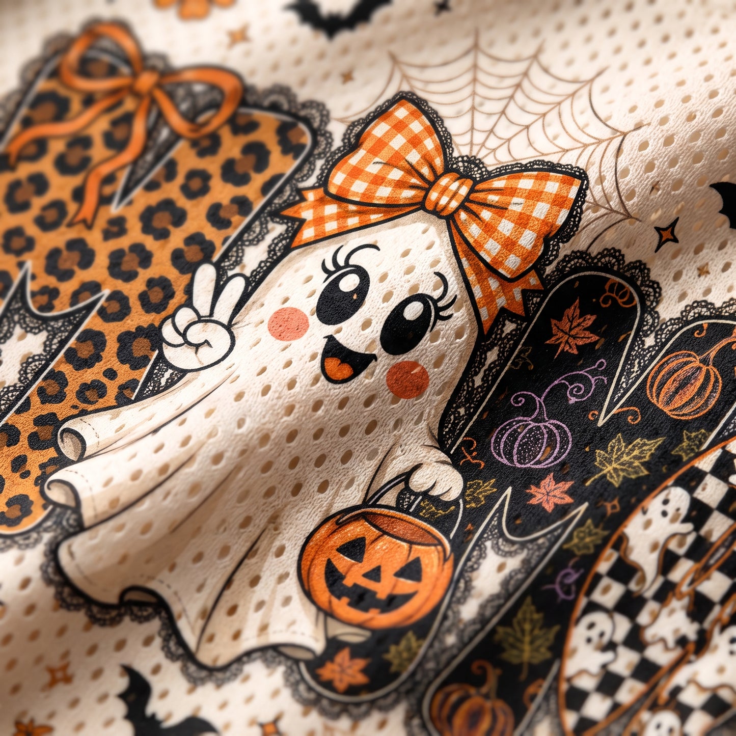 Close-up of a Halloween-themed fabric print featuring a cute cartoon ghost in an orange gingham bow, holding a jack-o'-lantern, with spiderwebs, pumpkins, bats, and patterned accents on a cream mesh background.